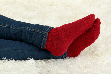 Female legs in colorful socks on  white carpet background