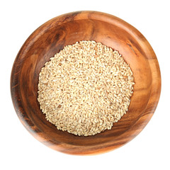 Raw buckwheat in wooden bowl isolated on white