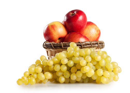 Grapes and apples in a basket isolated on white background