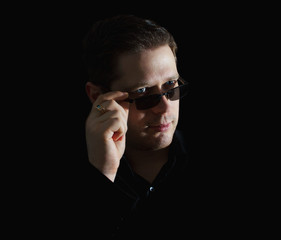 Portrait of man in black suit on black background