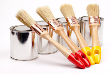 Cans of paint with paintbrushes  isolated on white