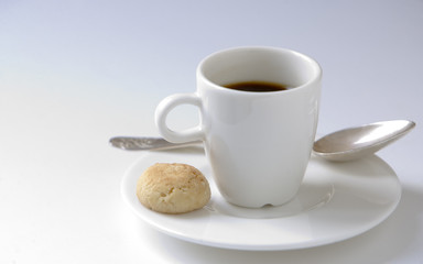 Black espresso coffee cup with steel spoon and small cookie