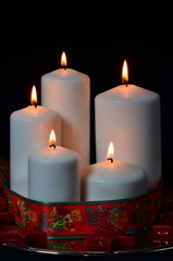 Obraz na płótnie Canvas White candles with red ribbon and stars