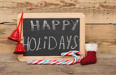 Handwritten happy holidays greeting on a small chalkboard with c