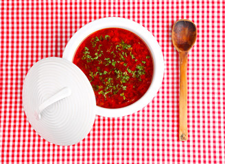 wooden spoon bowl with borsch on a checked cloth