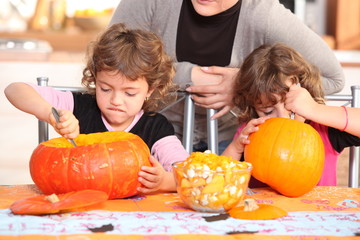Naklejka premium Children carving halloween pumpkins