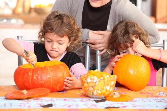 Children carving halloween pumpkins