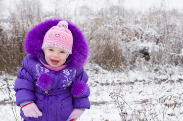 Portrait of happy little girl in snowy landscape