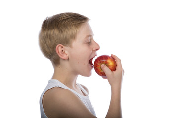 Junge isst einen roten Apfel