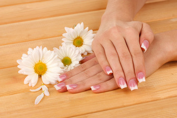 Obraz na płótnie Canvas Woman hands with french manicure and flowers