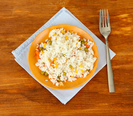 Risotto on color plate on wooden background