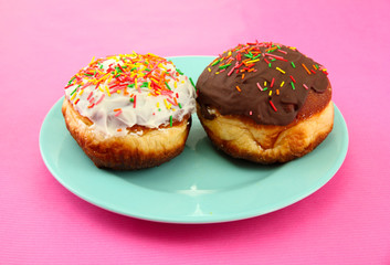 Tasty donuts on color plate on color background