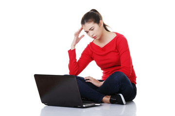 Sad woman looking on laptop screen.