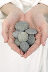 Fototapeta na wymiar Ręce gospodarstwa gładkie okrągłe kamienie
