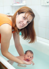 Mother bathes newborn baby