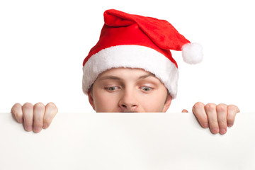 Young man in santa hat holding a blank sign