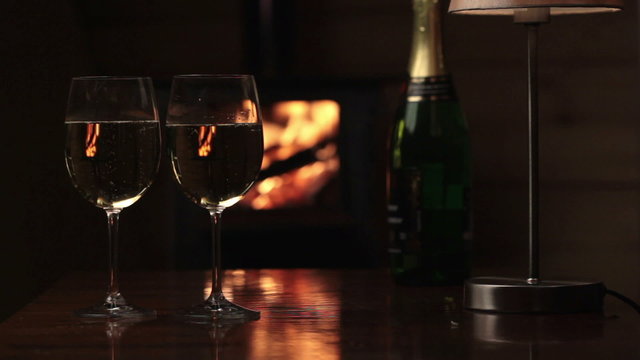 Glasses of champagne near fireplace