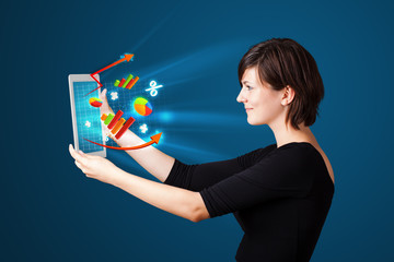 Young woman looking at modern tablet with abstract lights and va