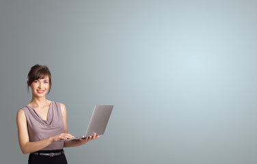 attractive woman holding a laptop with copy space