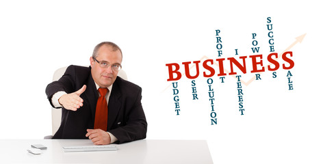 businesman sitting at desk with business word cloud