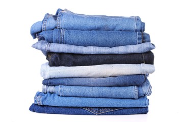 stack of different kind of blue jeans, on white background