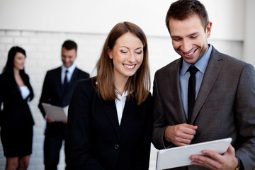 Two Happy business people working with digital tablet