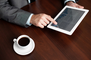 Fototapeta na wymiar Businessman using digital tablet by the desk