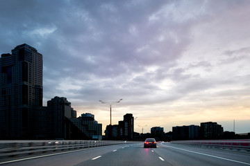 Car enters the city nightlife. The urban landscape.