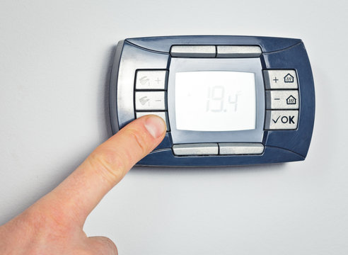 Finger pushing thermostat control button