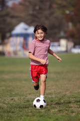 Boy playing soccer in the park
