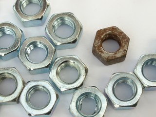 Metal nuts scattered on the white plane