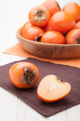 Exotic tropic orange fruits  persimmon served in wooden plate