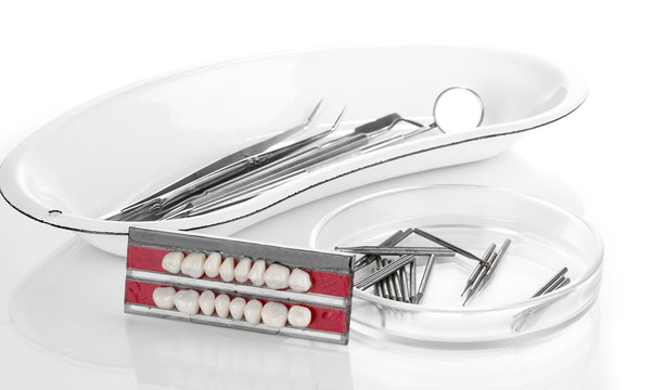 denture with dental tools isolated on white