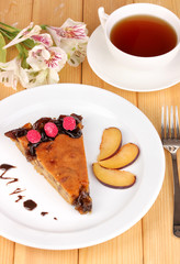 Tasty pie on plate on wooden table