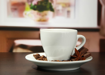 cup of coffee with beans on table in cafe