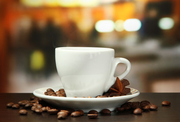 cup of coffee with beans on table in cafe