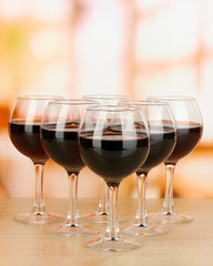 Red wine in glass on room background