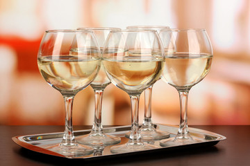 White wine in glass on room background