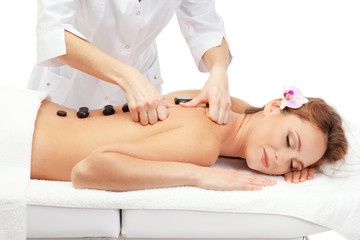 beautiful woman in spa salon with spa stones  getting massage,