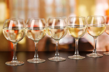 White wine in glass on room background