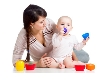 kid girl and mother playing together with cup toys