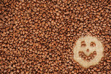 face coffee frame made of coffee beans on burlap texture