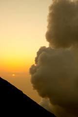 smoking volcano at sunset