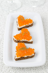 three sandwich with red caviar in the form of a heart