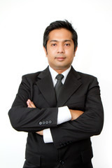 Businessman with crossed arms smiling on a white background