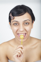 Obraz na płótnie Canvas Young girl eating lollipop
