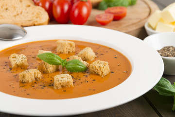 Cream of tomato soup with croutons, black pepper & basil leaves