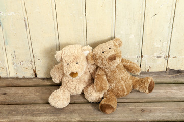 two teddybears on wood