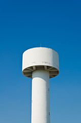 Fototapeta na wymiar White water tower in the blue sky