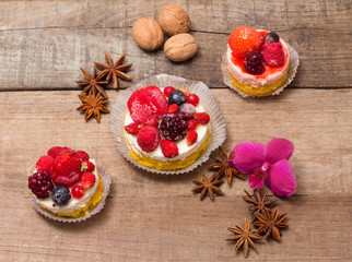 delicious cupcakes with berries over wood